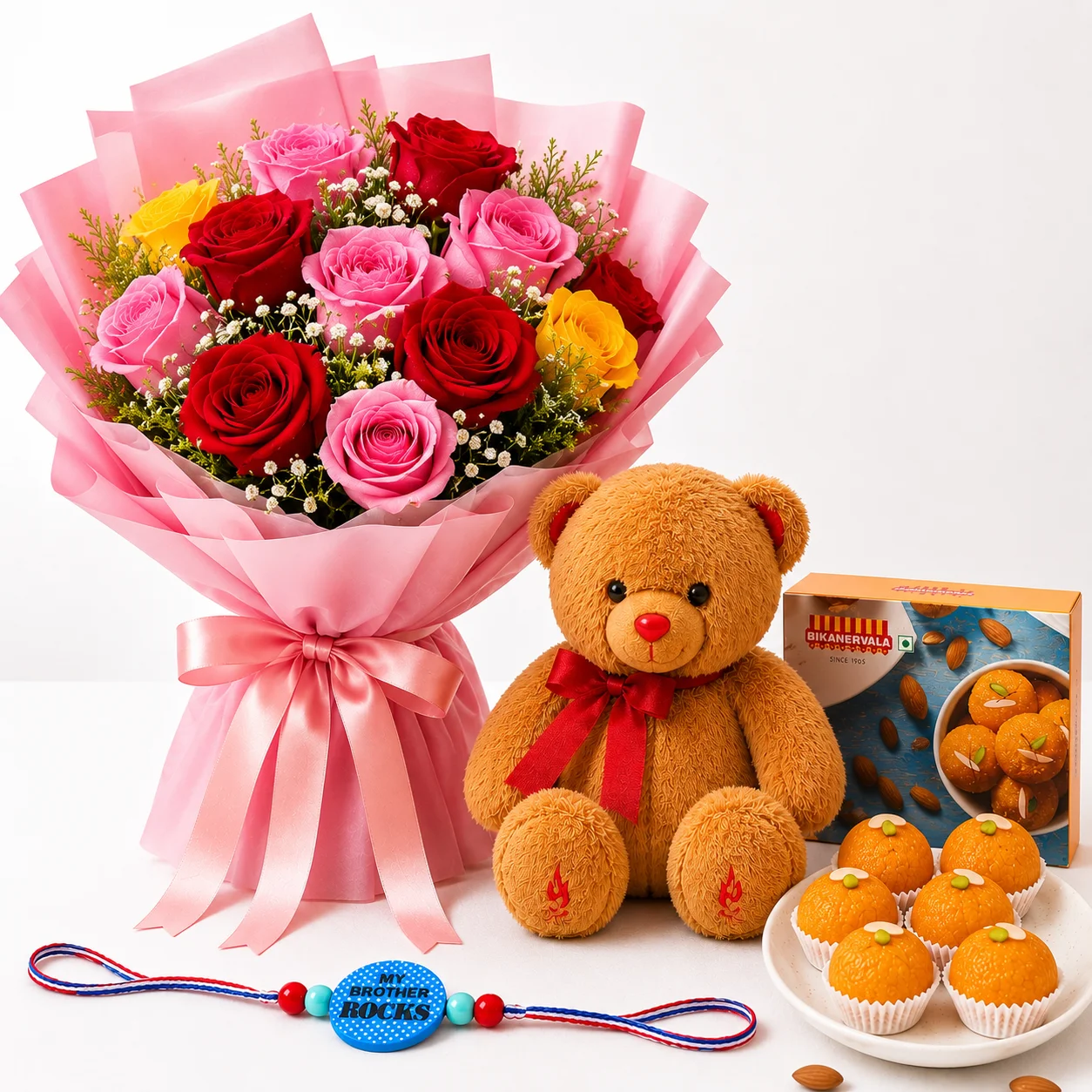 My Brother Rocks Floral Combo with pink, red and yellow roses, teddy, motichur laddoo and My Brother Rocks rakhi